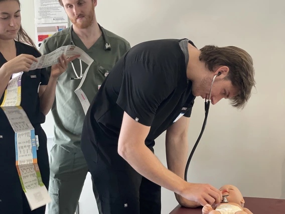 student doctor examining a baby