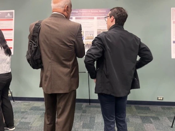 Two doctors looking at a project poster