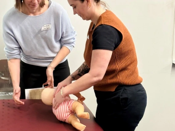 two medical student working on a simulated baby patient