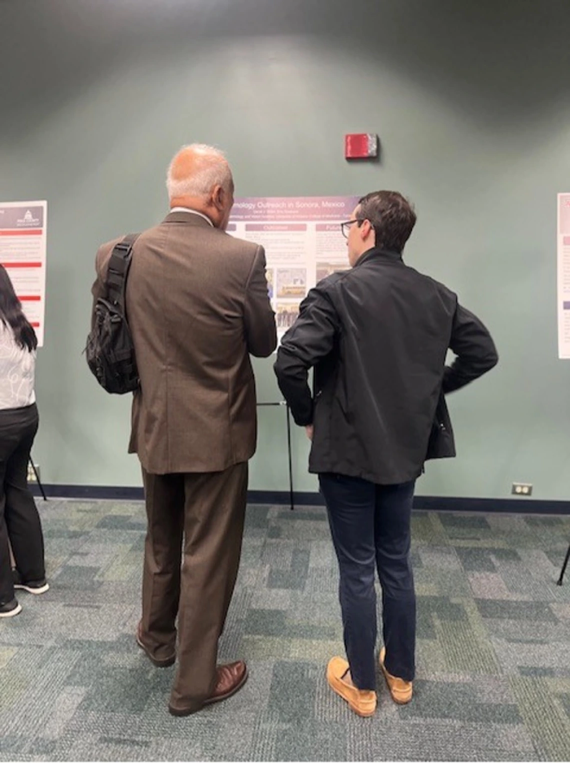 Two doctors looking at a project poster