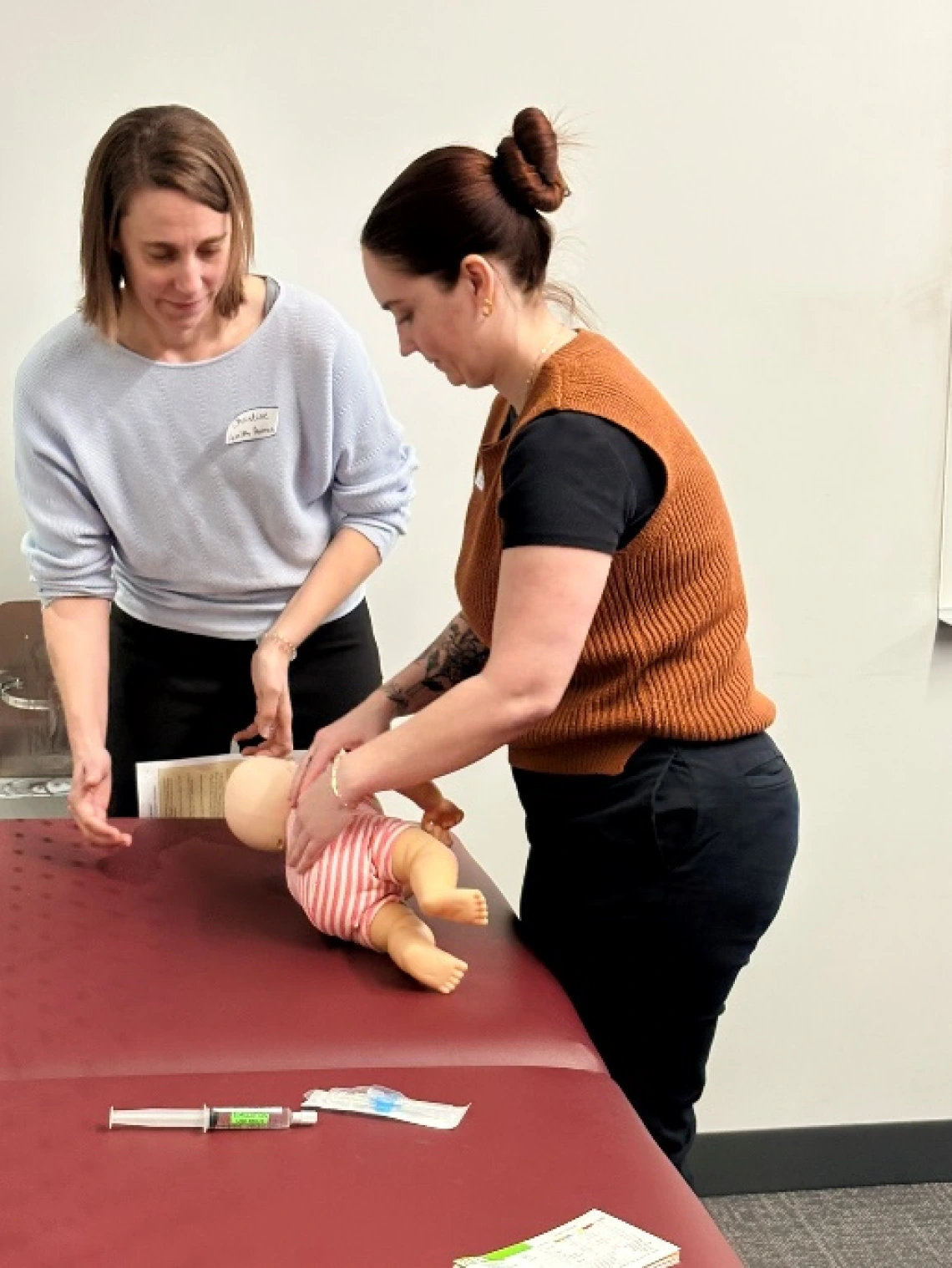 two medical student working on a simulated baby patient